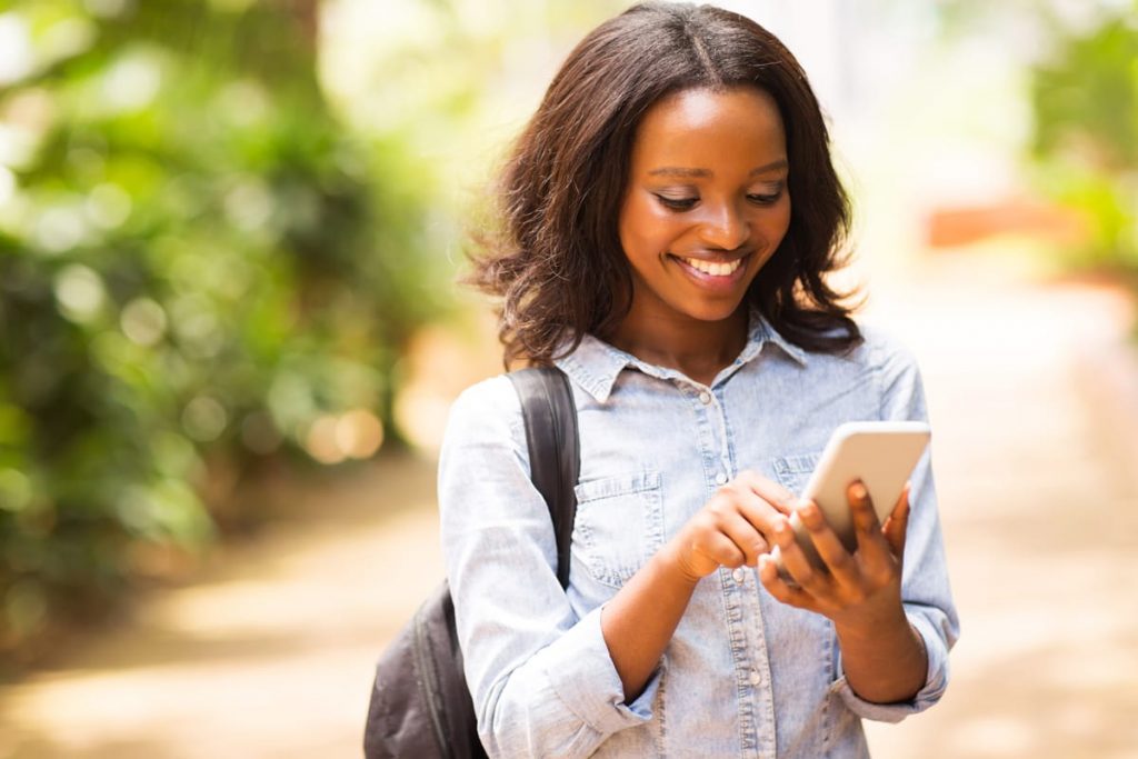 school graduate texting on an iphone