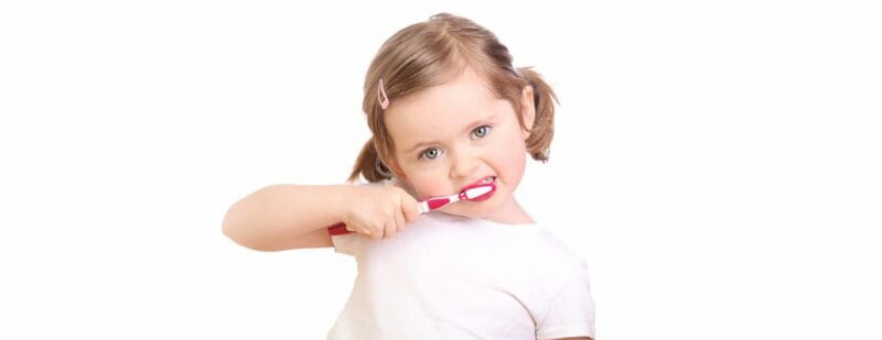 young toddler brushing her teeth