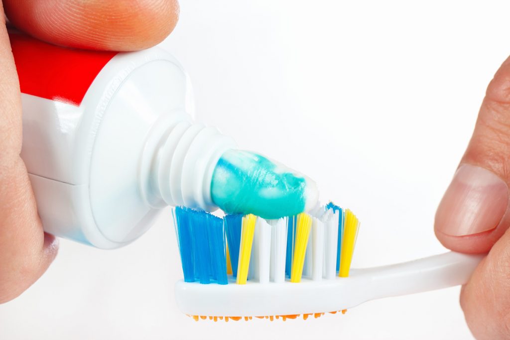 toothpaste being put on a toothbrush