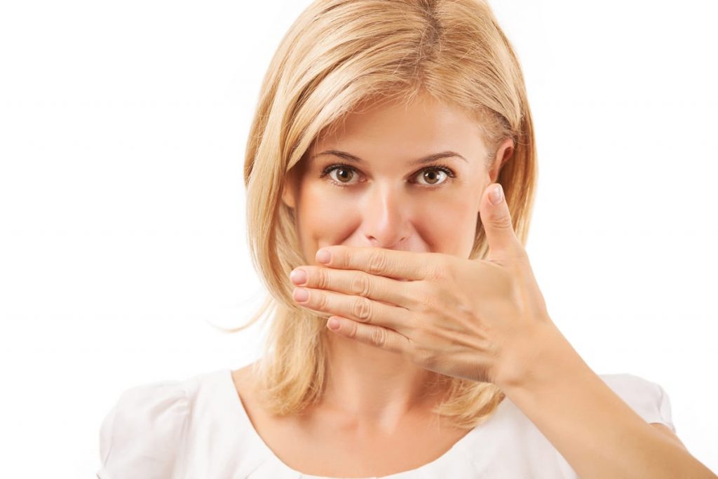 woman covering her mouth with embarrassment