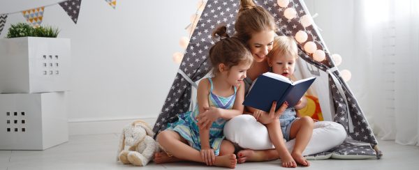 mom reading a book to her children