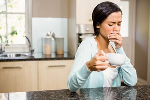 woman holding her mouth in pain